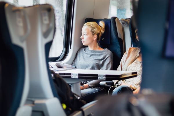 femme assise dans un train regardant par la fenêtre