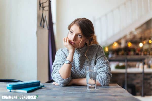 femme en attente devant un verre d'eau